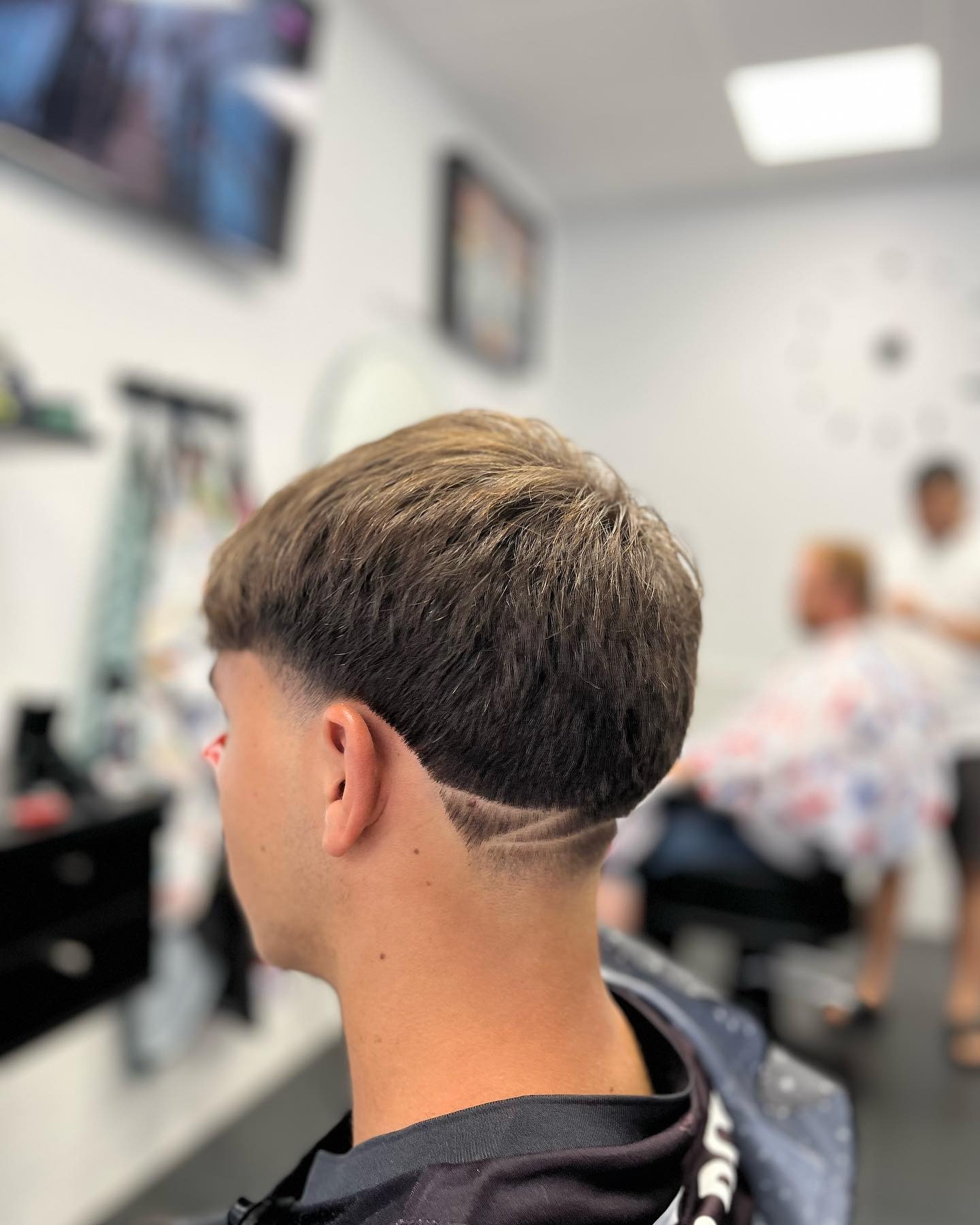 Corte con flequillo y degradado bajo, visto de perfil.
